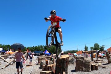 Jeff Anderson drops off a tree stump with his trials bike