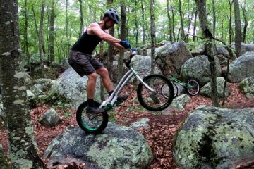 Travis Brown balances on his rear bike's wheel on a rock