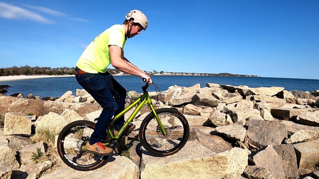 Ryan rides his Inspired Fourplay trials bike in a technical line across the "field" of granite rocks