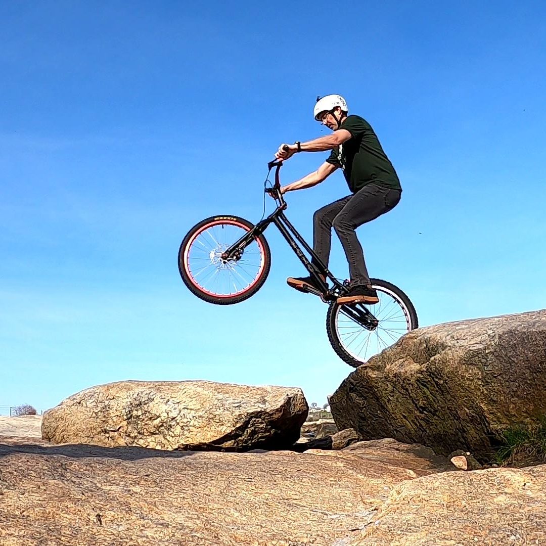 Tim does a small rear wheel drop gap on his trials bike from a rock ledge to a boulder