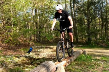 Riding a bike along a rotting log