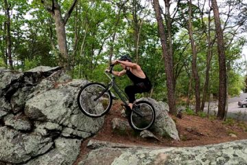 Mike balances his trials bike on the rear wheel atop a small rock just before launching into a sidehop