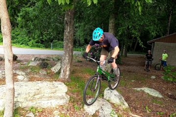 Jim balances his trials bike with each wheel on a different rock