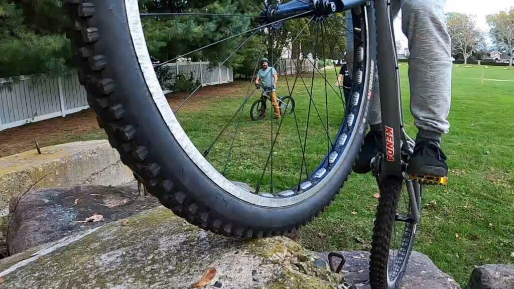 Close-up of Mike balancing his bike on concrete blocks