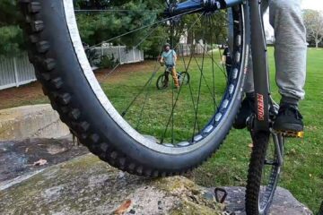 Close-up of Mike balancing his bike on concrete blocks
