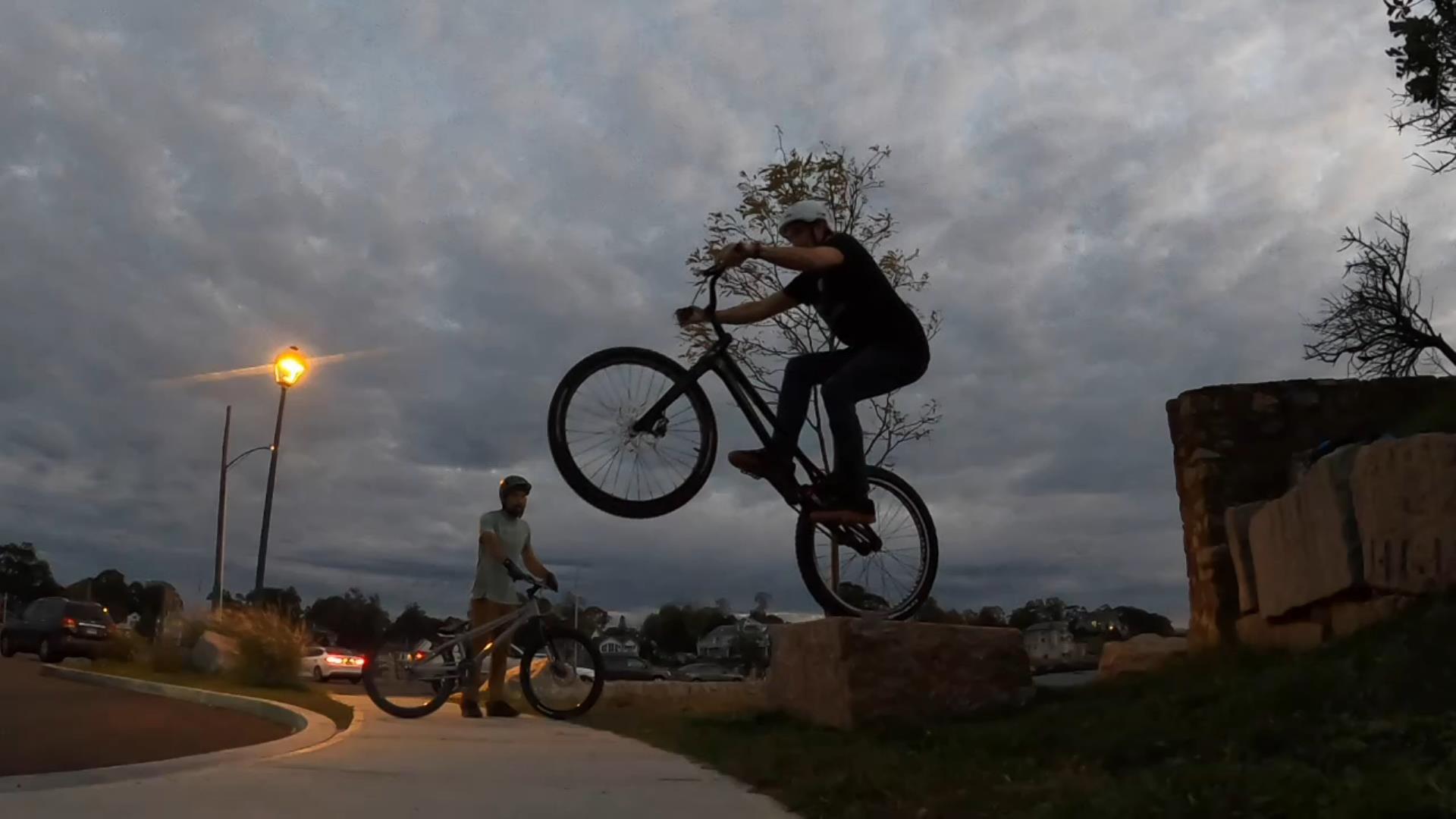 Preparing to rear-wheel drop from a granite slab