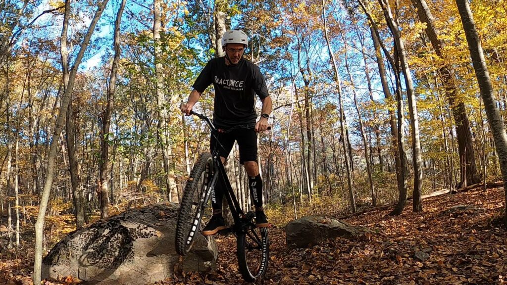 Tim pivots his trials bike off a boulder