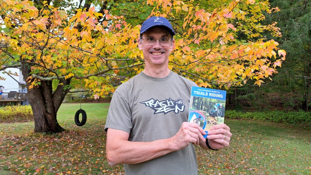 Tim holding the book Your Complete Guide To Trials Riding - Street Trials Augmented Edition, by Julien Happich